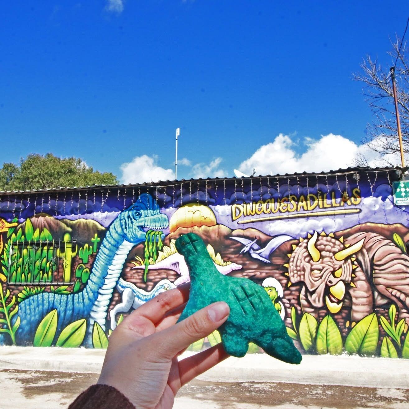 Dinoquesadilla frente al mural de dinosaurios